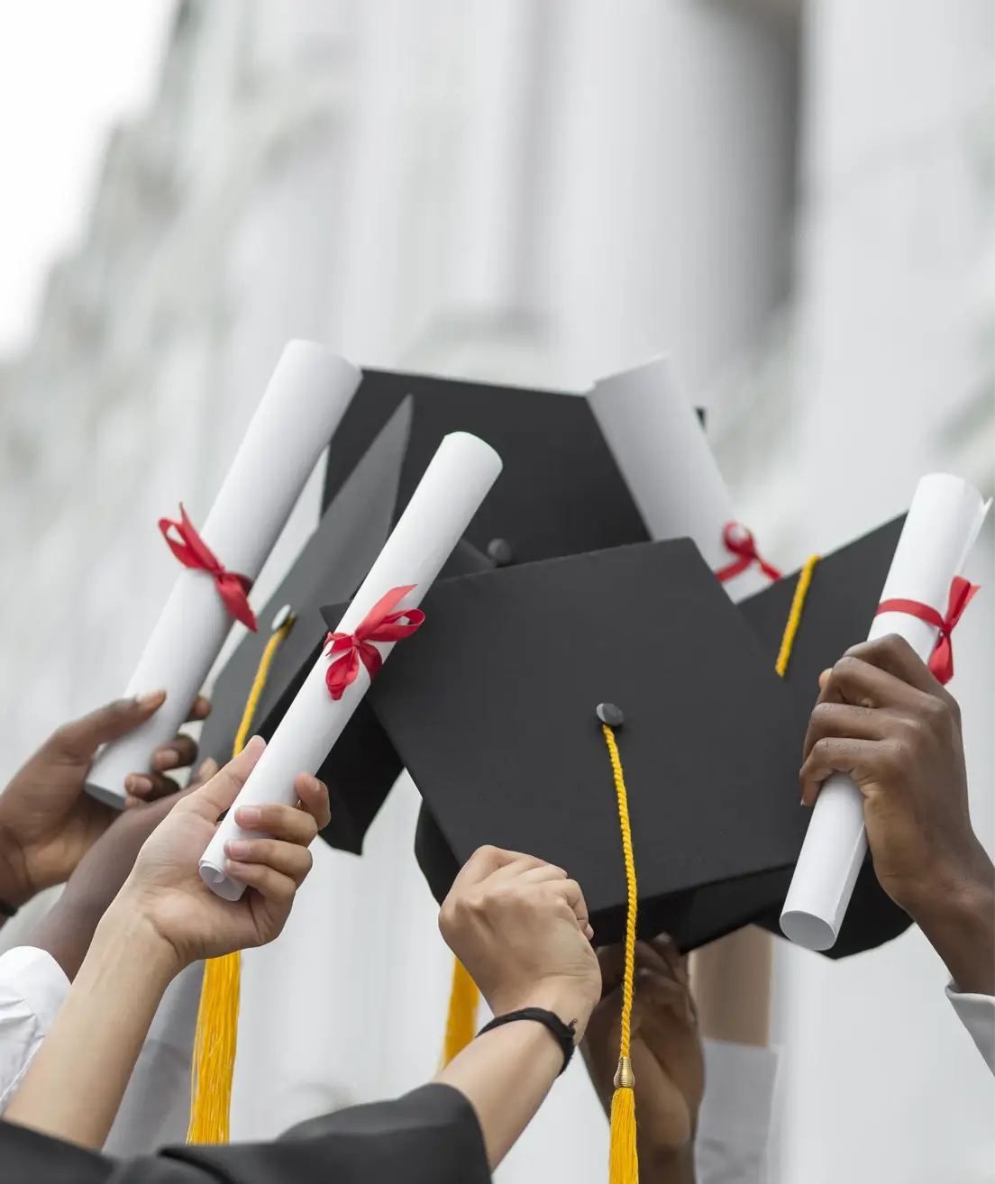 Close-up hands holding diplomas caps
